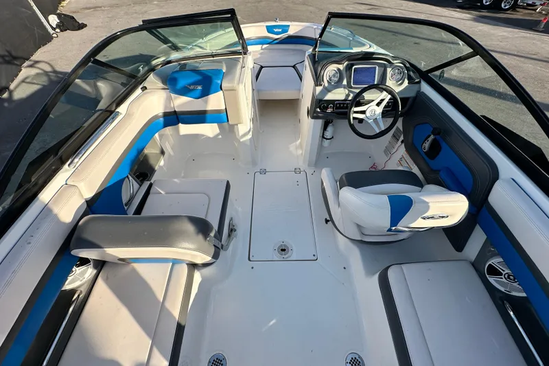 Slide: The Image of 2019 Chaparral Vortex 2430 VRX boat interior with blue and white seating, steering console. - 14