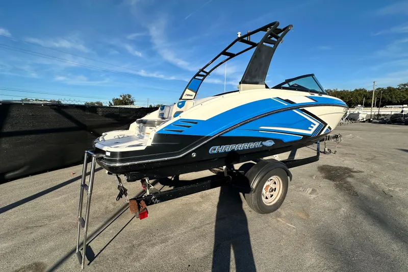Slide: The Image of 2019 Chaparral Vortex 2430 VRX boat on trailer, featuring blue and white design. - 2