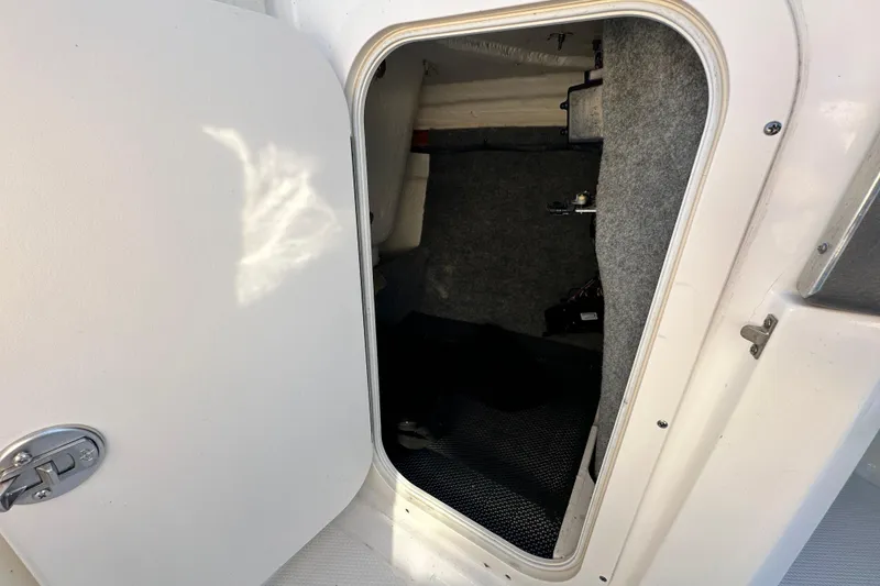 Slide: The Image of 2019 Chaparral Vortex 2430 VRX storage compartment with open door, showing interior details. - 67