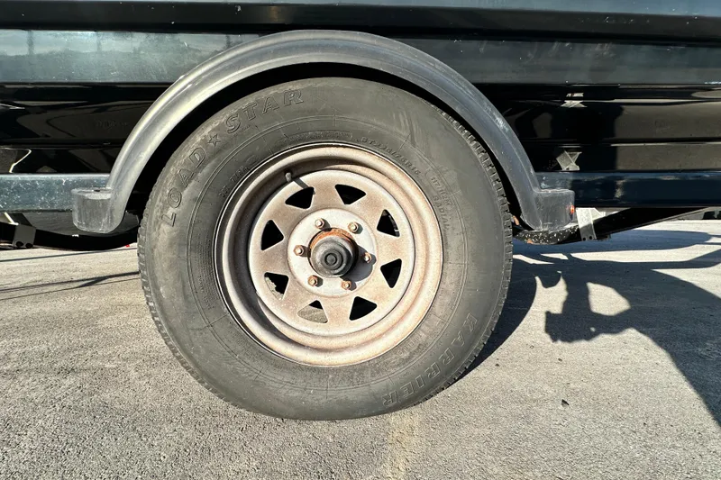 Slide: The Image of Trailer wheel of a 2019 Chaparral Vortex 2430 VRX boat on pavement. - 90