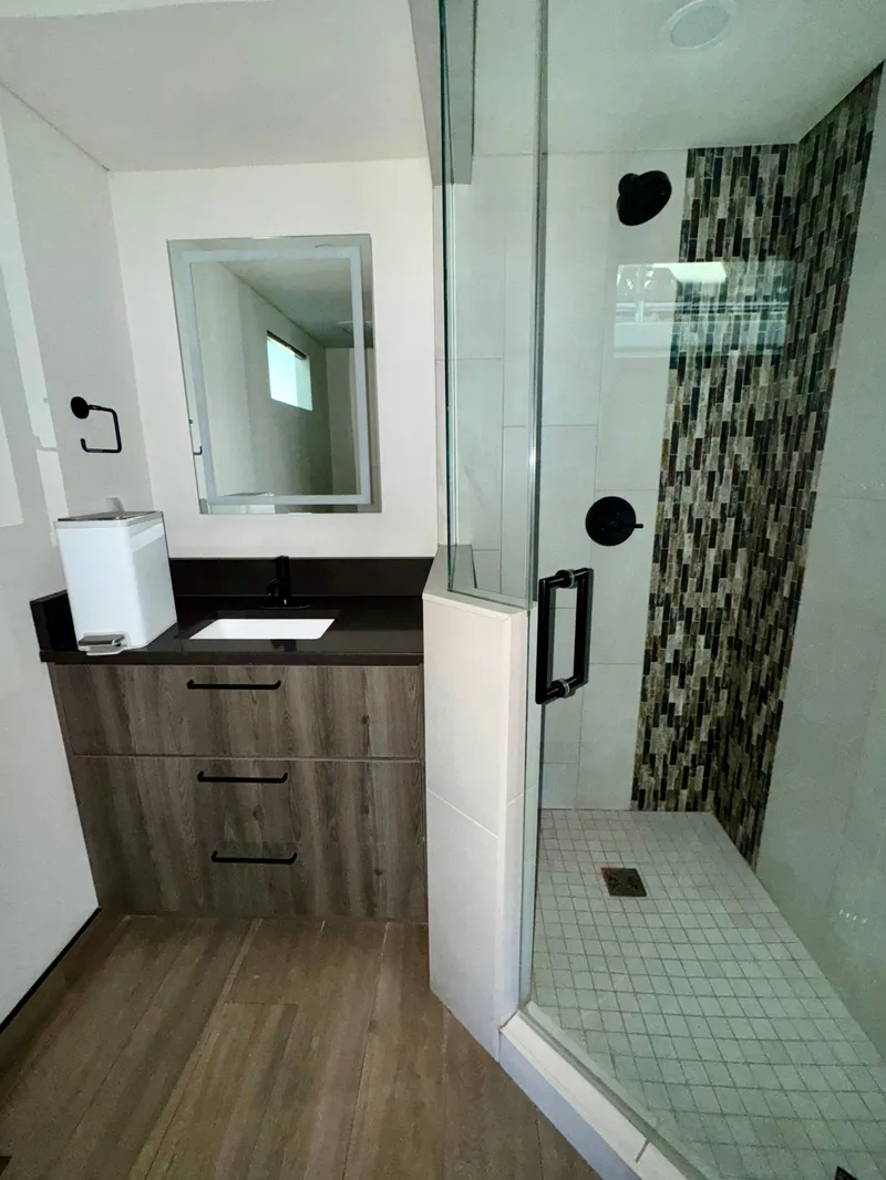 Slide: The Image of Modern bathroom with glass shower, wood vanity, and sleek fixtures in Adonia Obsession Share Trip #9. - 16