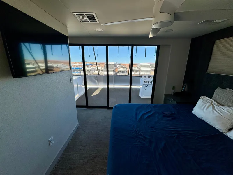 Slide: The Image of Modern bedroom with large windows, blue bedding, and a wall-mounted TV in Adonia Obsession Share Trip #9. - 23