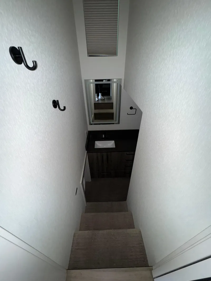 Slide: The Image of Narrow staircase leading to a small bathroom with a sink and mirror, Adonia Obsession Share Trip #9. - 9