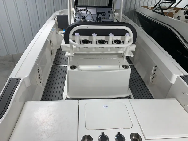 Slide: The Image of 2024 Bayliner Trophy 20CC center console boat interior with rod holders and storage compartments. - 13