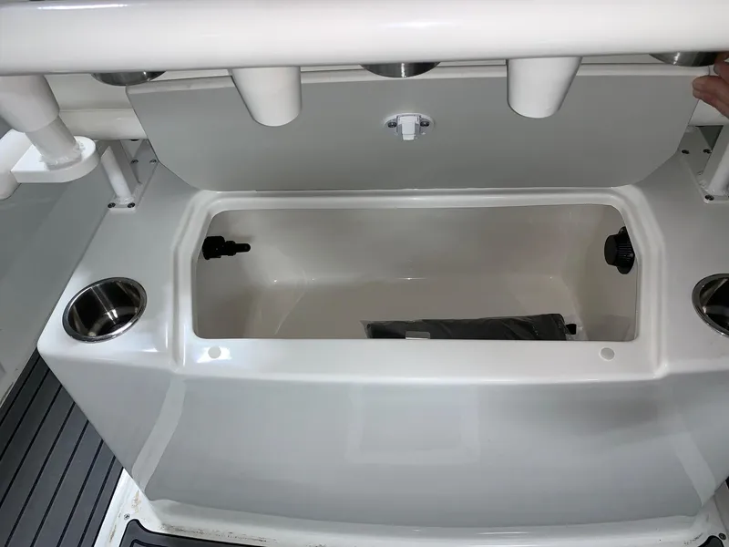 Slide: The Image of 2024 Bayliner Trophy 20CC boat storage compartment with cup holders and rod holders. - 3