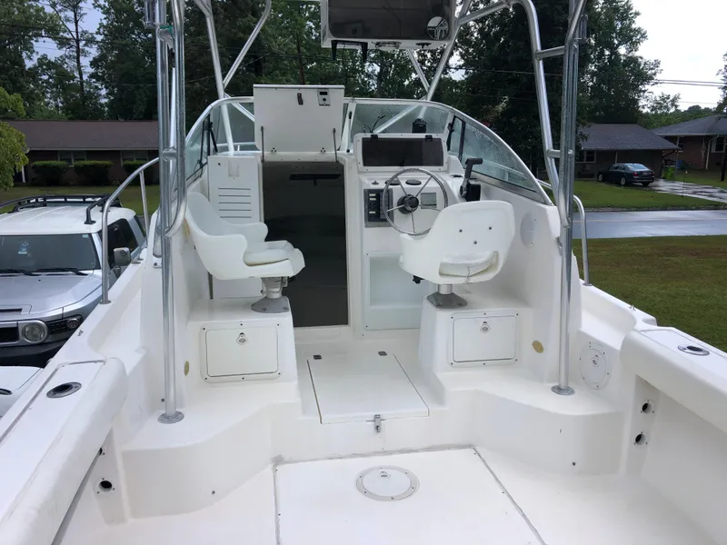 Slide: The Image of 2000 Cobia 240 Walk-Around boat interior with dual seats and steering console. - 6