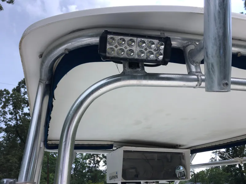 Slide: The Image of T-top of 2000 Cobia 240 Walk-Around boat with mounted LED light and Garmin equipment. - 8