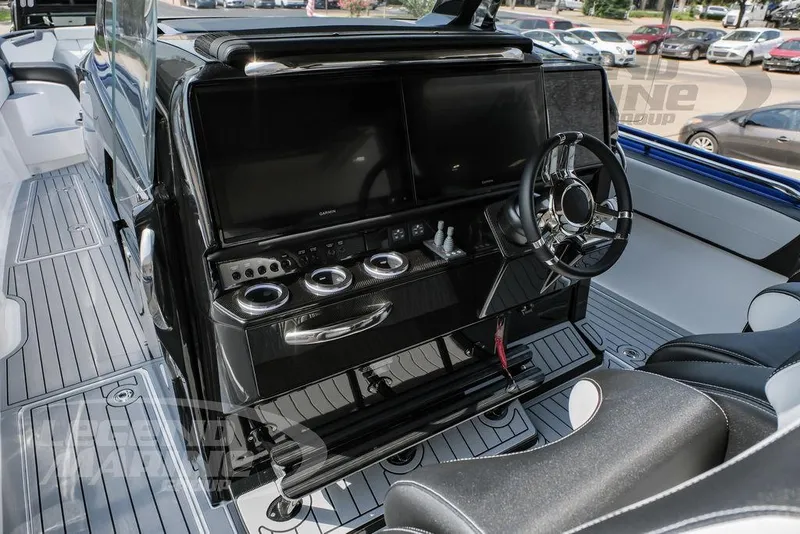 Slide: The Image of 2025 Nor-Tech 450 Sport boat cockpit with dual screens and sleek steering wheel. - 12