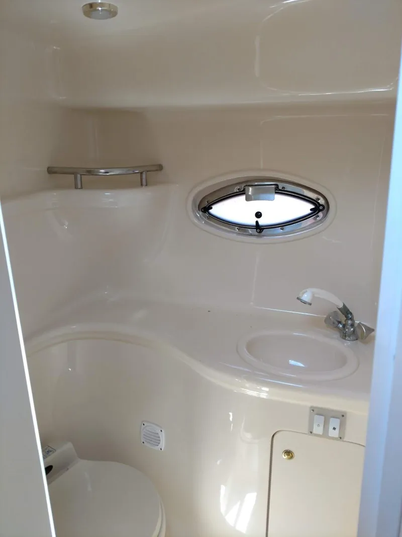 Slide: The Image of 2001 Sea Ray 290 Amberjack bathroom with sink, porthole, and storage. - 15