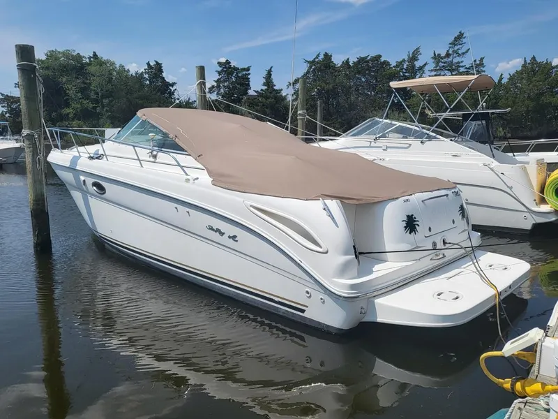 Slide: The Image of 2001 Sea Ray 290 Amberjack boat docked with cover, calm water, clear sky. - 3