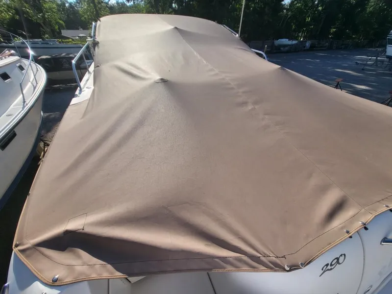 Slide: The Image of 2001 Sea Ray 290 Amberjack covered with a tan boat cover. - 42