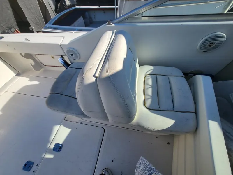 Slide: The Image of 2001 Sea Ray 290 Amberjack boat interior with white cushioned seating and speaker. - 48