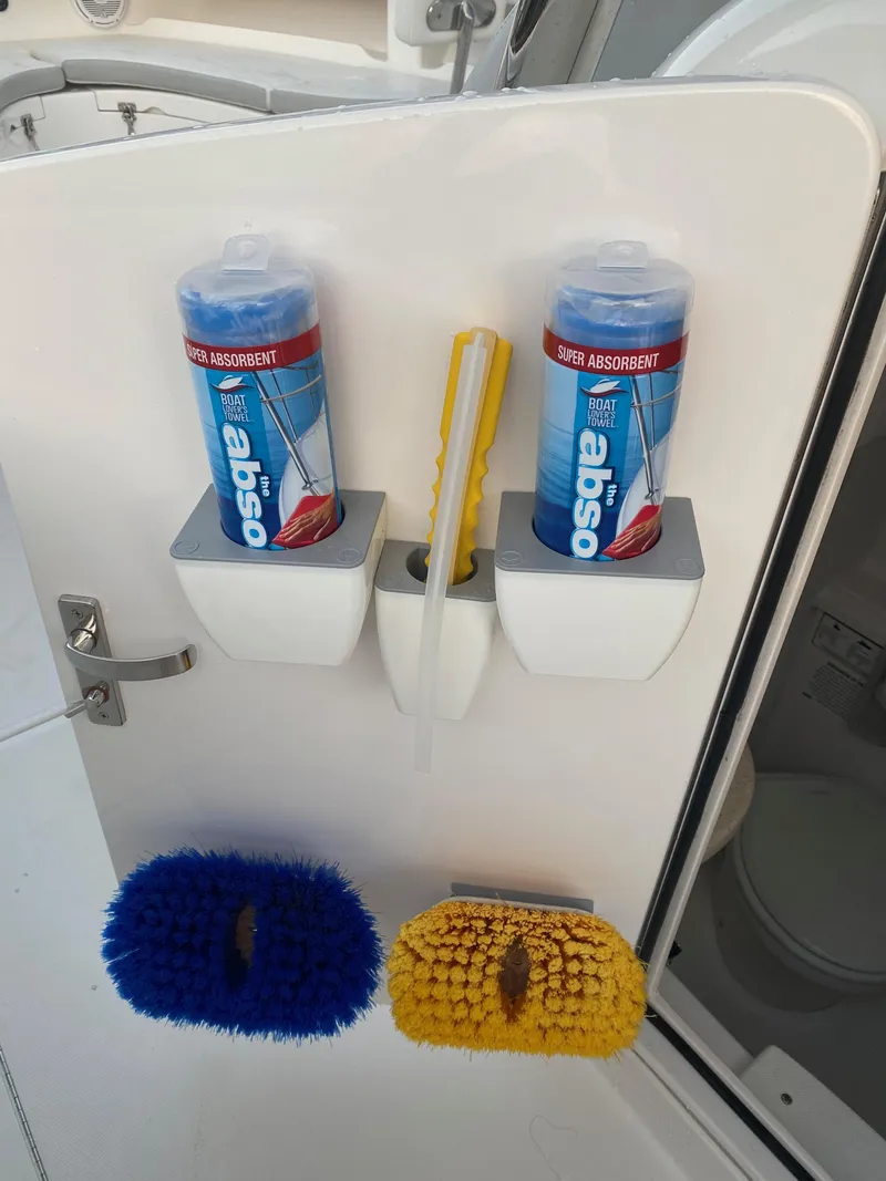 Slide: The Image of 2019 Mag Bay Center Console boat with cleaning supplies and brushes mounted on a white panel. - 10
