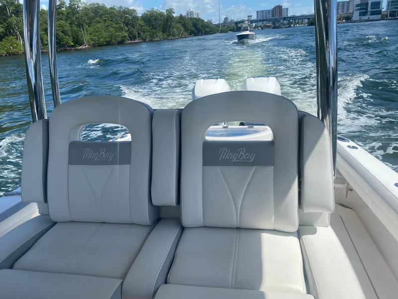 Slide: The Image of 2019 Mag Bay Center Console boat with white seating, cruising on a scenic waterway. - 4