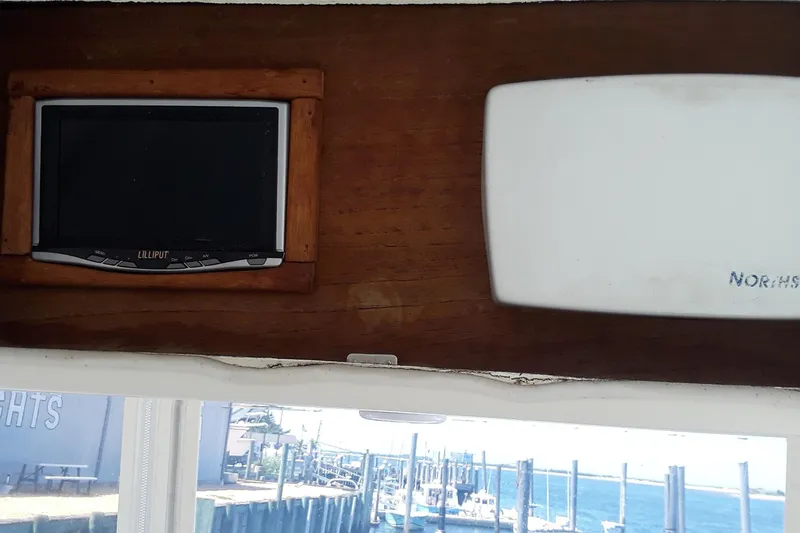 Slide: The Image of 1987 Blackfin 36 Convertible interior with electronics and window view of marina. - 19