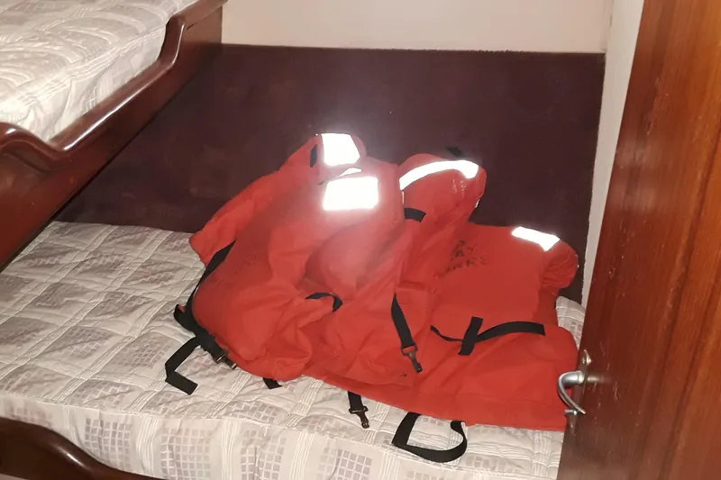 Slide: The Image of Red life jackets on a bed inside a 1987 Blackfin 36 Convertible boat. - 30