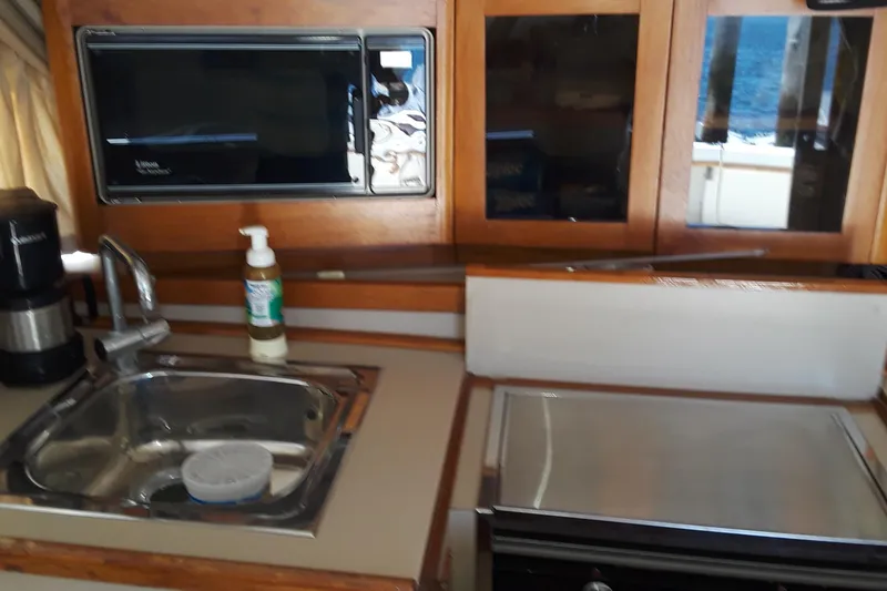 Slide: The Image of 1987 Blackfin 36 Convertible boat kitchen with sink, microwave, and stove. - 35