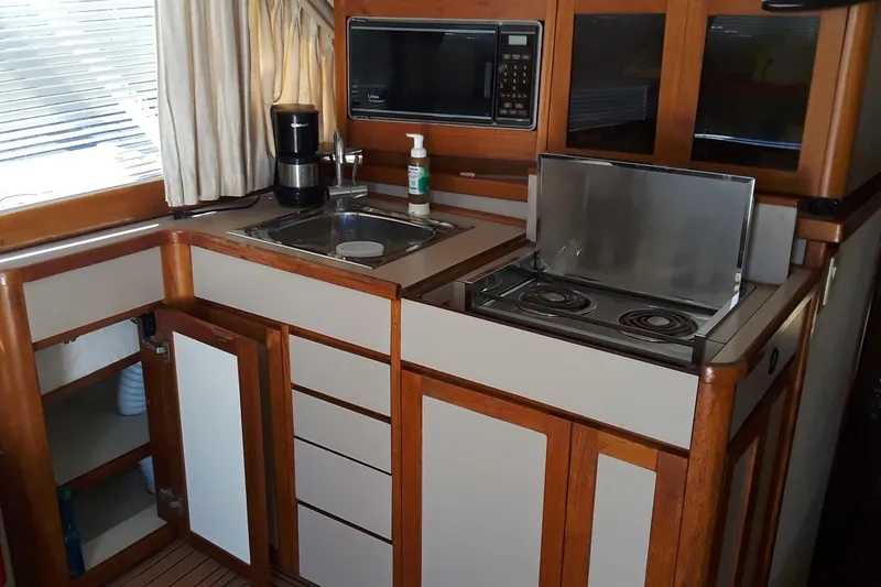 Slide: The Image of 1987 Blackfin 36 Convertible boat kitchen with sink, stove, microwave, and storage cabinets. - 37