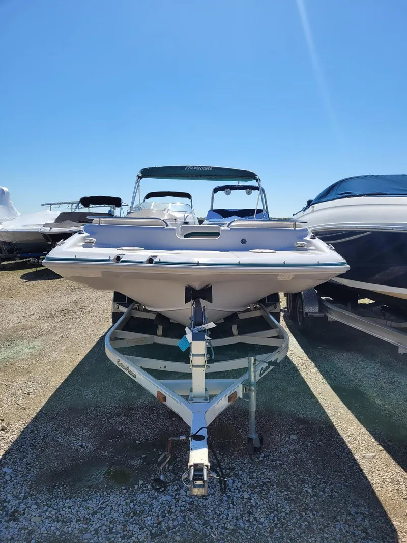 Slide: The Image of 2000 Hurricane Fun Deck 201IO boat on trailer, parked outdoors. - 11