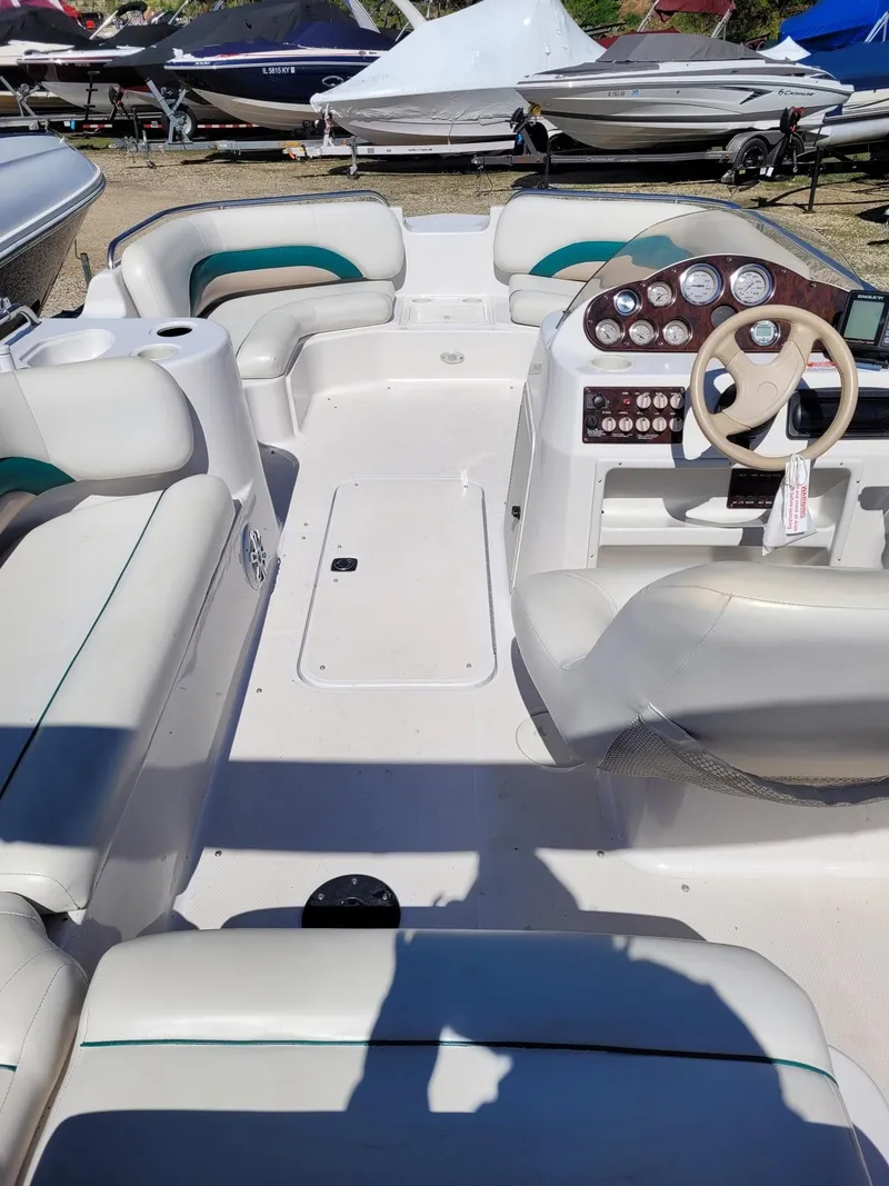 Slide: The Image of 2000 Hurricane Fun Deck 201IO boat interior with white and teal seating, dashboard, and steering wheel. - 4