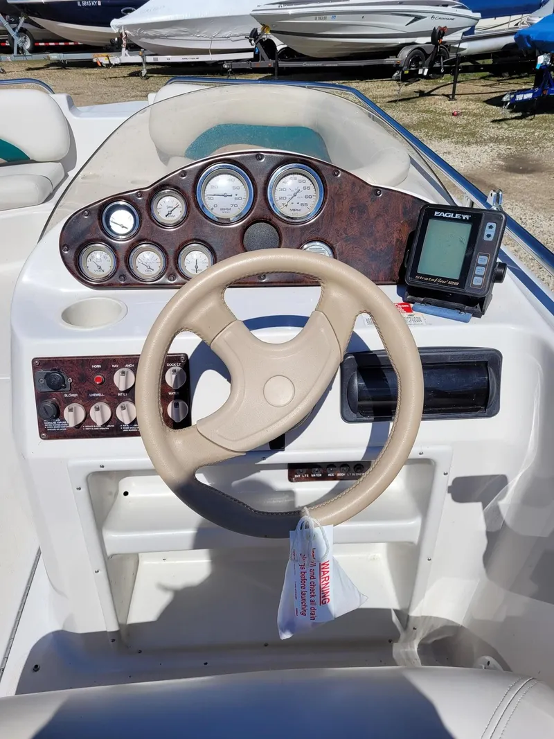 Slide: The Image of Dashboard of a 2000 Hurricane Fun Deck 201IO boat with steering wheel and gauges. - 5