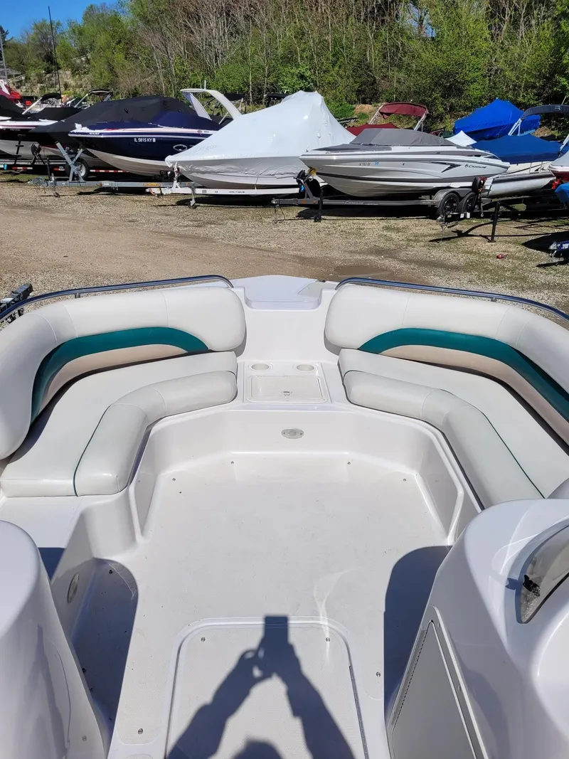 Slide: The Image of 2000 Hurricane Fun Deck 201IO boat interior with seating, parked among other boats. - 8