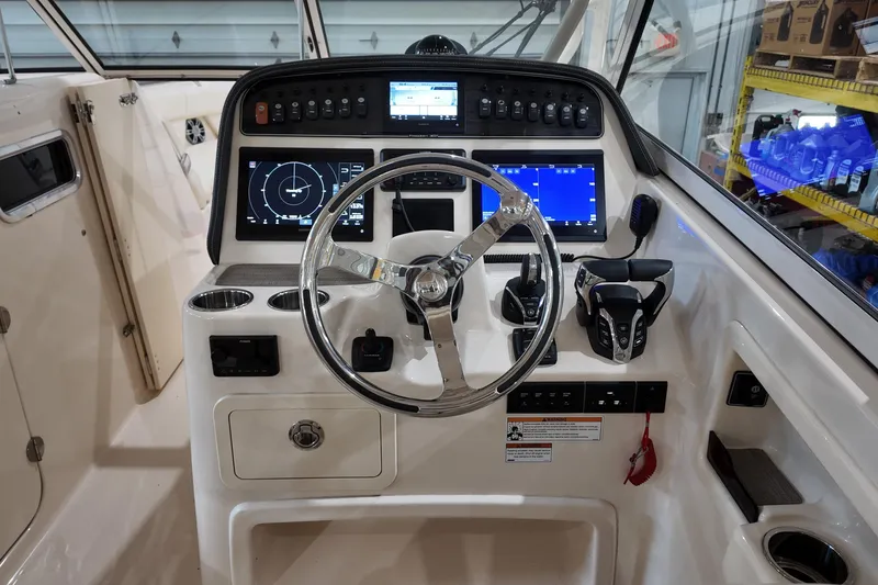 Slide: The Image of 2024 Grady-White Freedom 307 boat dashboard with advanced navigation displays and controls. - 12