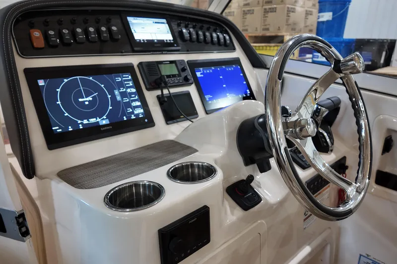 Slide: The Image of 2024 Grady-White Freedom 307 boat dashboard with steering wheel and controls. - 13