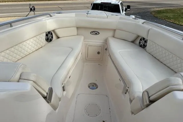 Slide: The Image of 2024 Grady-White Freedom 307 boat interior with white cushioned seating and speakers. - 20
