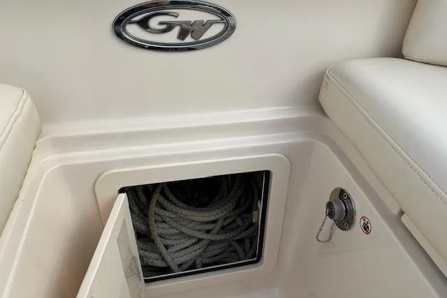 Slide: The Image of 2024 Grady-White Freedom 307 boat storage compartment with coiled rope and GW logo. - 22
