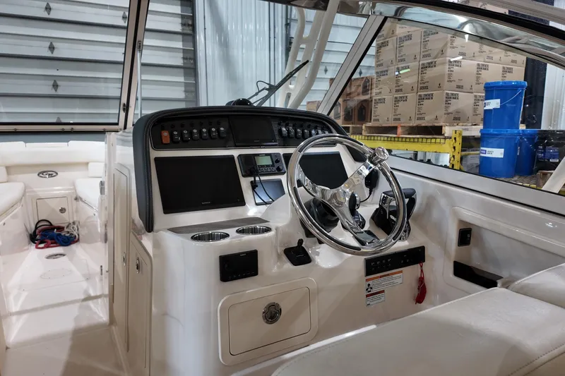 Slide: The Image of 2024 Grady-White Freedom 307 boat cruising on a serene lake with lush green trees. - 3