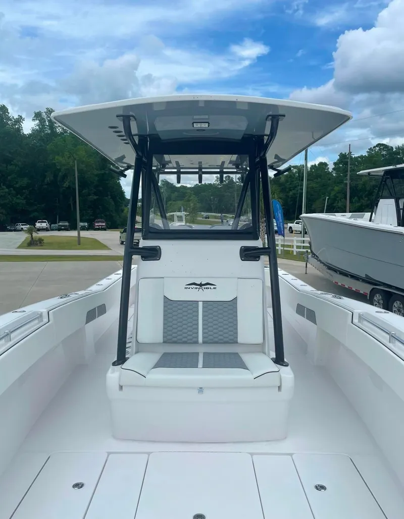 Slide: The Image of 2024 Invincible 33 Open Fisherman boat with T-top and seating, docked under a blue sky. - 3