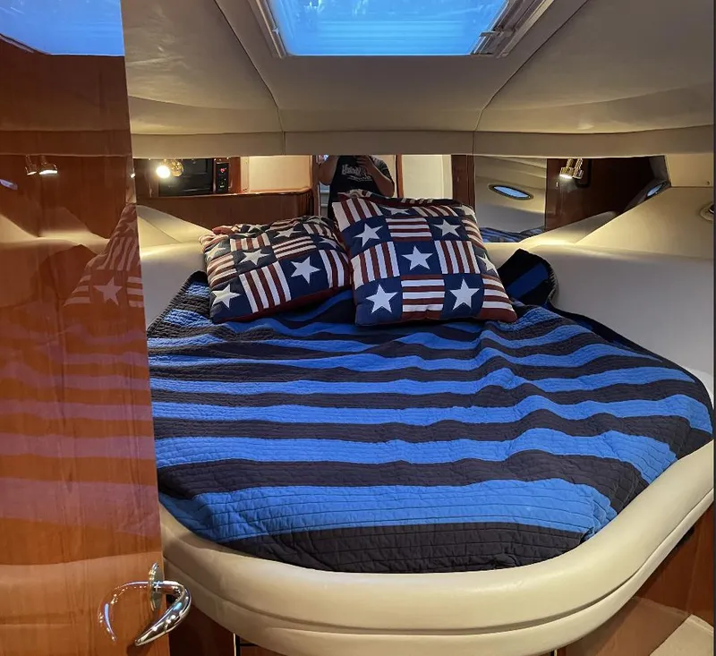 Slide: The Image of Cozy bedroom in 2000 Sea Ray 540 Sundancer yacht with striped bedding and star-themed pillows. - 12