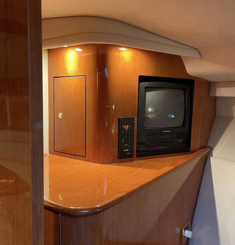 Slide: The Image of 2000 Sea Ray 540 Sundancer interior with TV and wooden cabinetry. - 13