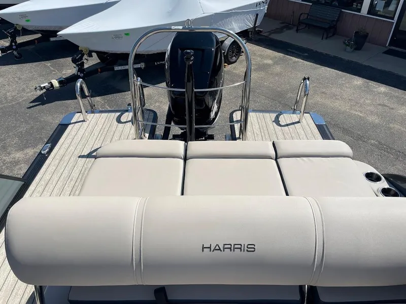 Slide: The Image of 2024 Harris 270 Grand Mariner boat with cushioned seating and outboard motor. - 13