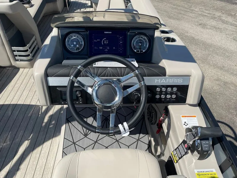 Slide: The Image of 2024 Harris 270 Grand Mariner boat dashboard with steering wheel and control panel. - 8