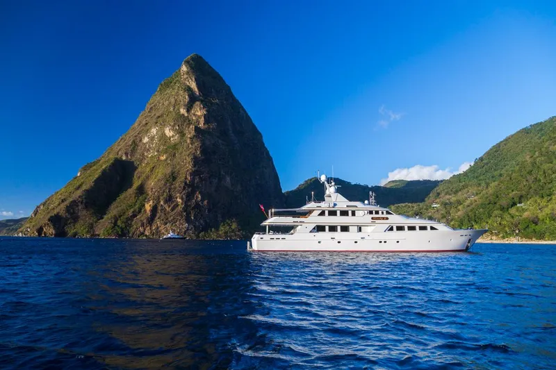 Slide: The Image of Palmer Johnson 1997 motor yacht cruising near a scenic mountain and blue ocean. - 0