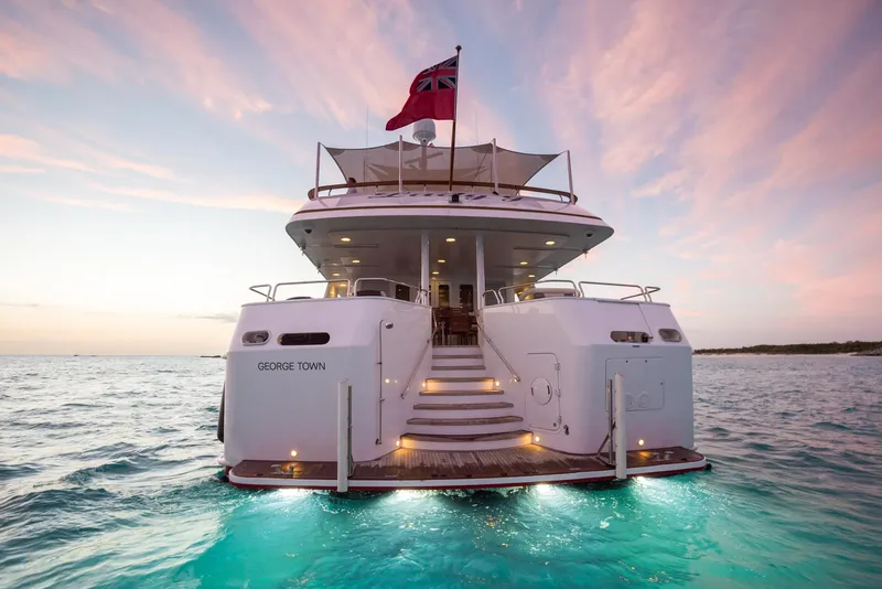Slide: The Image of Palmer Johnson 1997 Motor Yacht at sunset, rear view with illuminated steps and flag. - 2