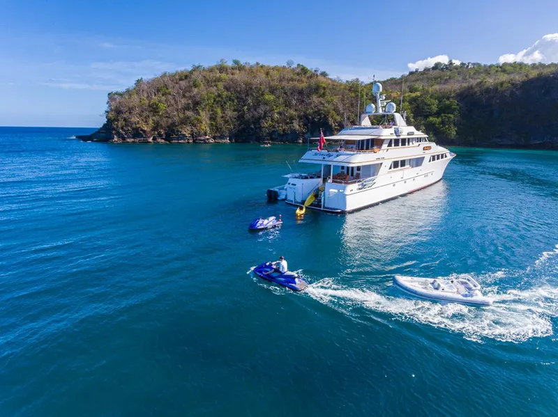 Slide: The Image of Palmer Johnson 1997 Motor Yacht anchored in a scenic bay with jet skis. - 21