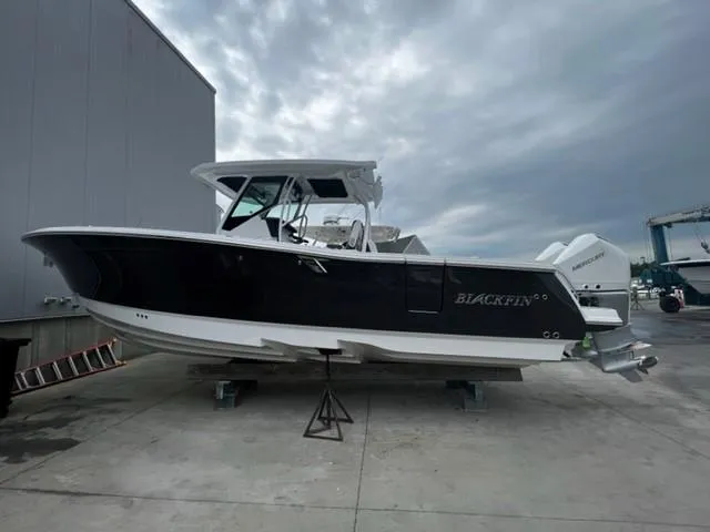 The Image of 2023 Blackfin 302 CC boat on a dock under cloudy skies. - 0