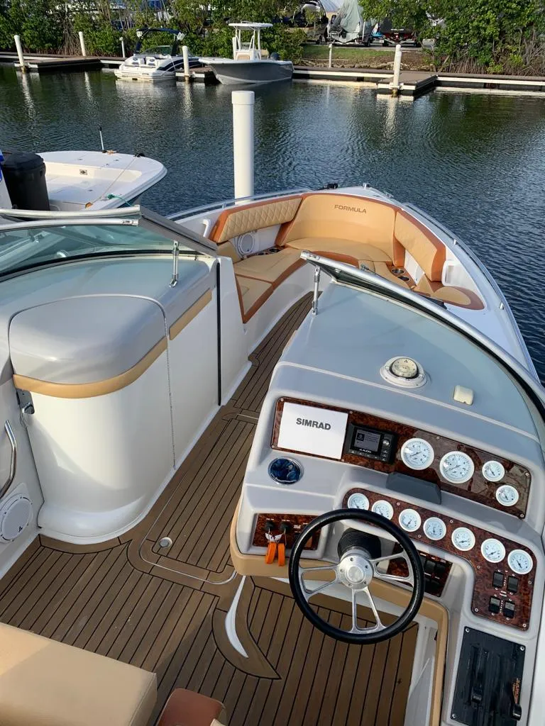Slide: The Image of 1999 Formula 280 Bowrider boat interior with dashboard and seating, docked at marina. - 1