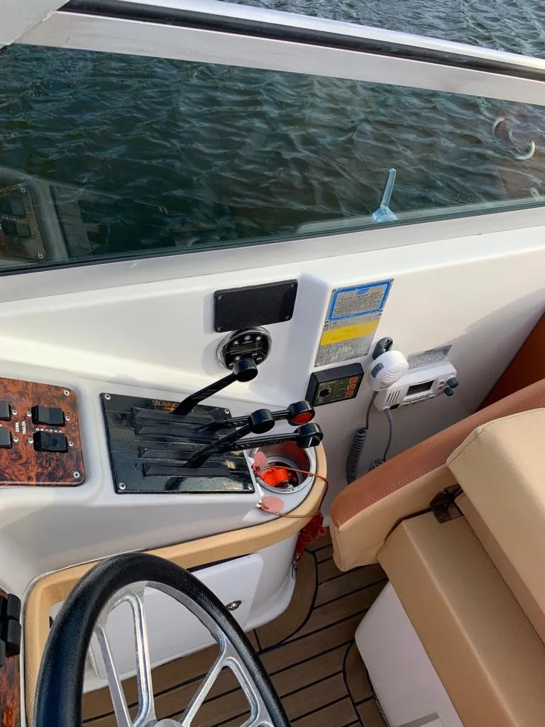 Slide: The Image of Control panel of a 1999 Formula 280 Bowrider boat with steering wheel and throttle levers. - 17