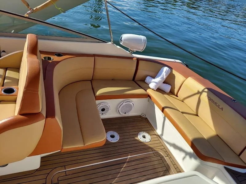 Slide: The Image of 1999 Formula 280 Bowrider boat interior with tan and brown seating, docked on water. - 27