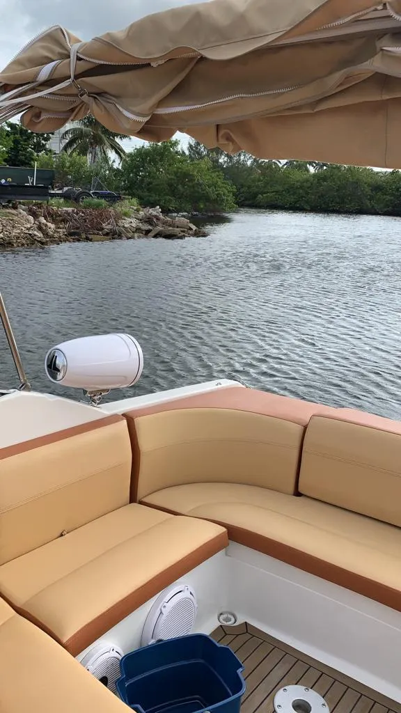 Slide: The Image of 1999 Formula 280 Bowrider boat with tan seating and canopy on a calm river. - 3