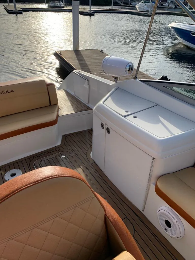 Slide: The Image of 1999 Formula 280 Bowrider boat interior with tan seating and dock in background. - 5