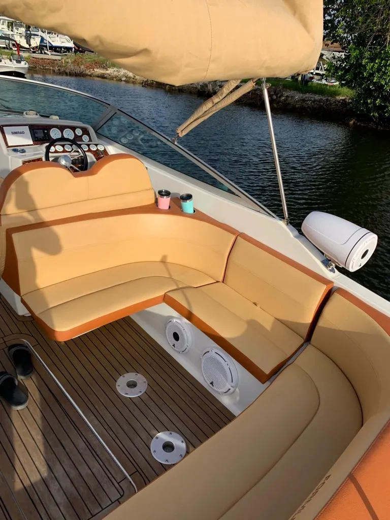 Slide: The Image of 1999 Formula 280 Bowrider with tan seating and wooden deck, docked by the water. - 6