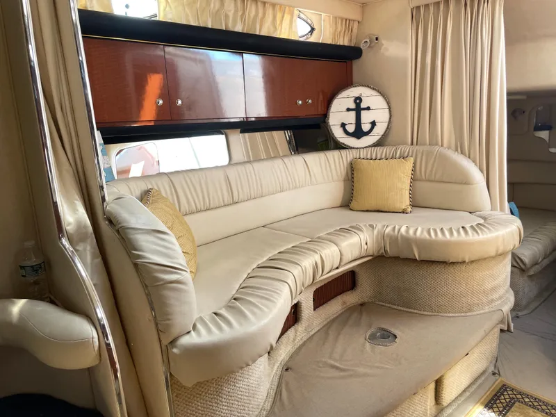 Slide: The Image of Interior of 2002 Sea Ray 340 Sundancer with beige leather seating and nautical decor. - 10