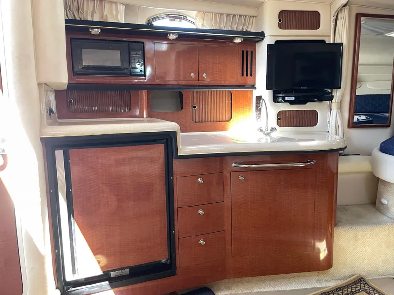 Slide: The Image of Interior of 2002 Sea Ray 340 Sundancer yacht with kitchenette and TV. - 12