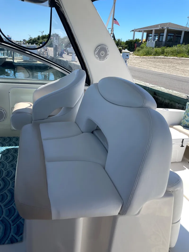Slide: The Image of 2002 Sea Ray 340 Sundancer cockpit seating with white upholstery. - 4