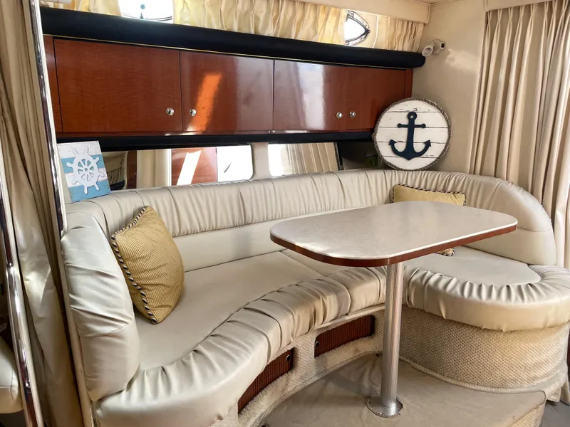 Slide: The Image of Interior of 2002 Sea Ray 340 Sundancer with cream leather seating and wooden cabinets. - 8